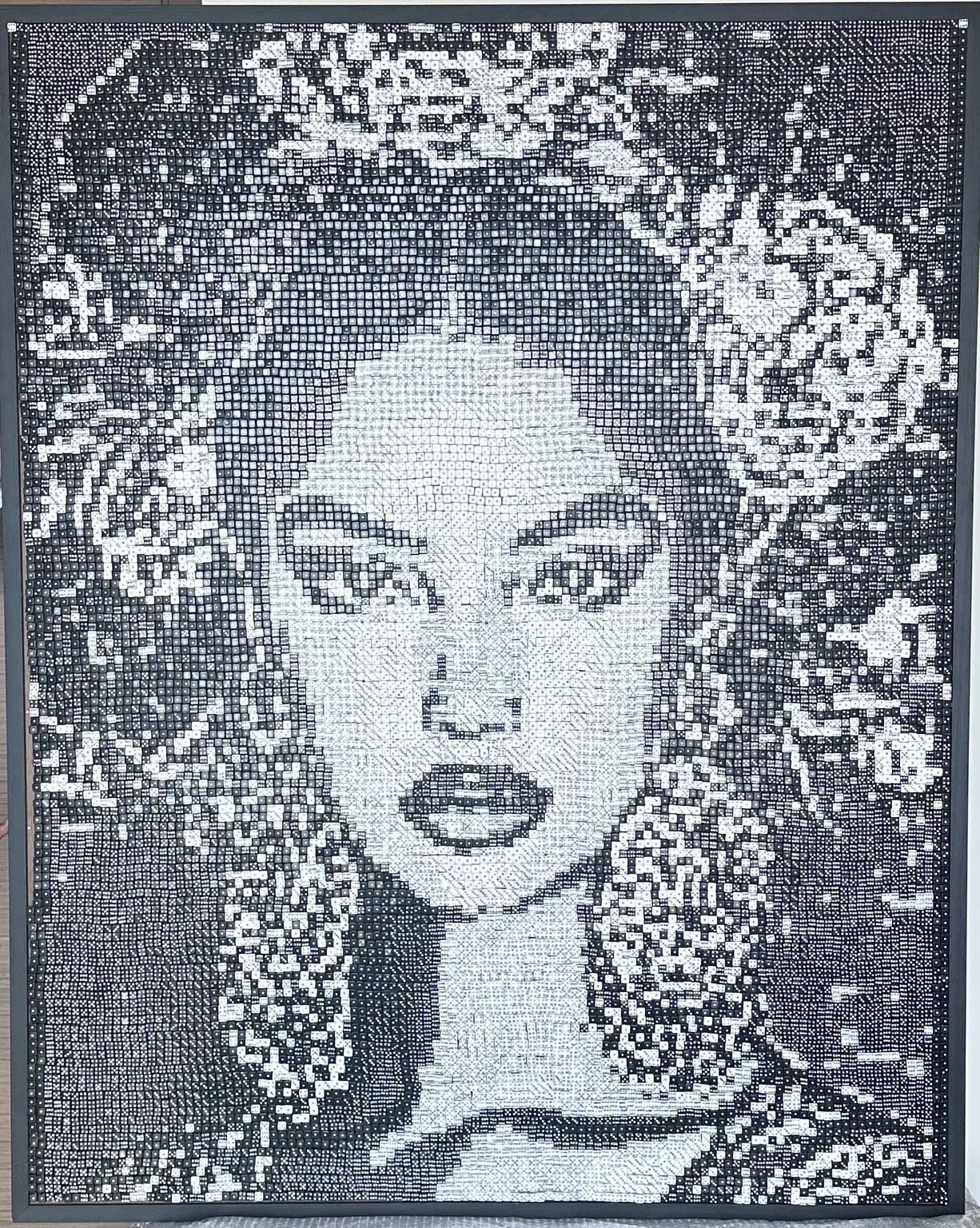 A large monochrome portrait composed entirely of black and white dice